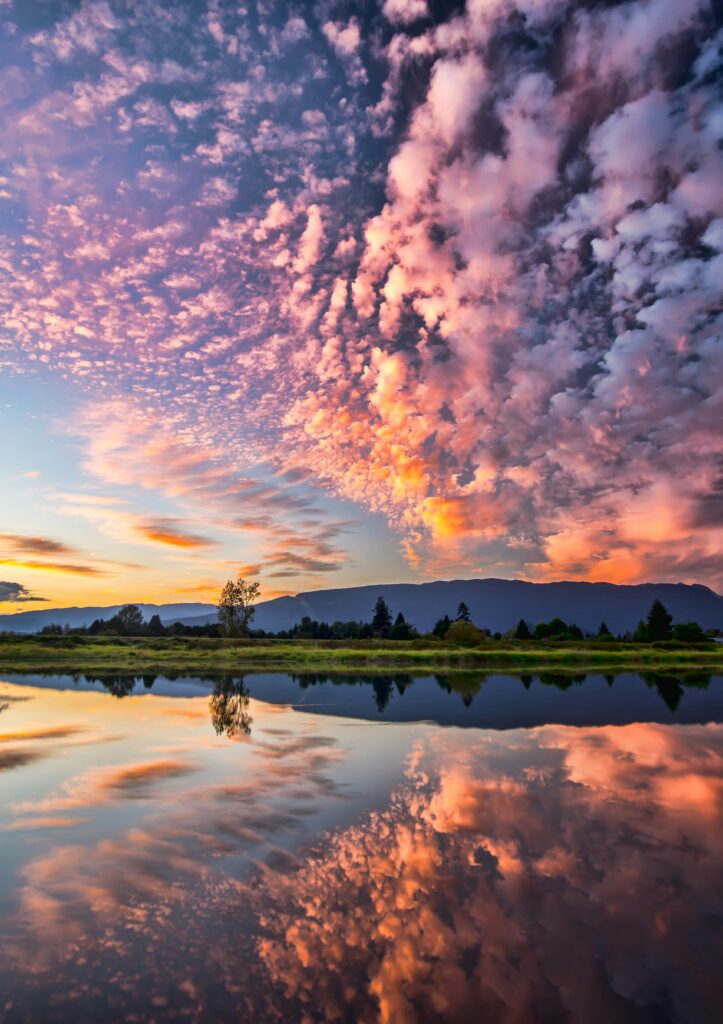 Captivating sunset with vibrant clouds and serene reflections over Pitt Meadows, BC.